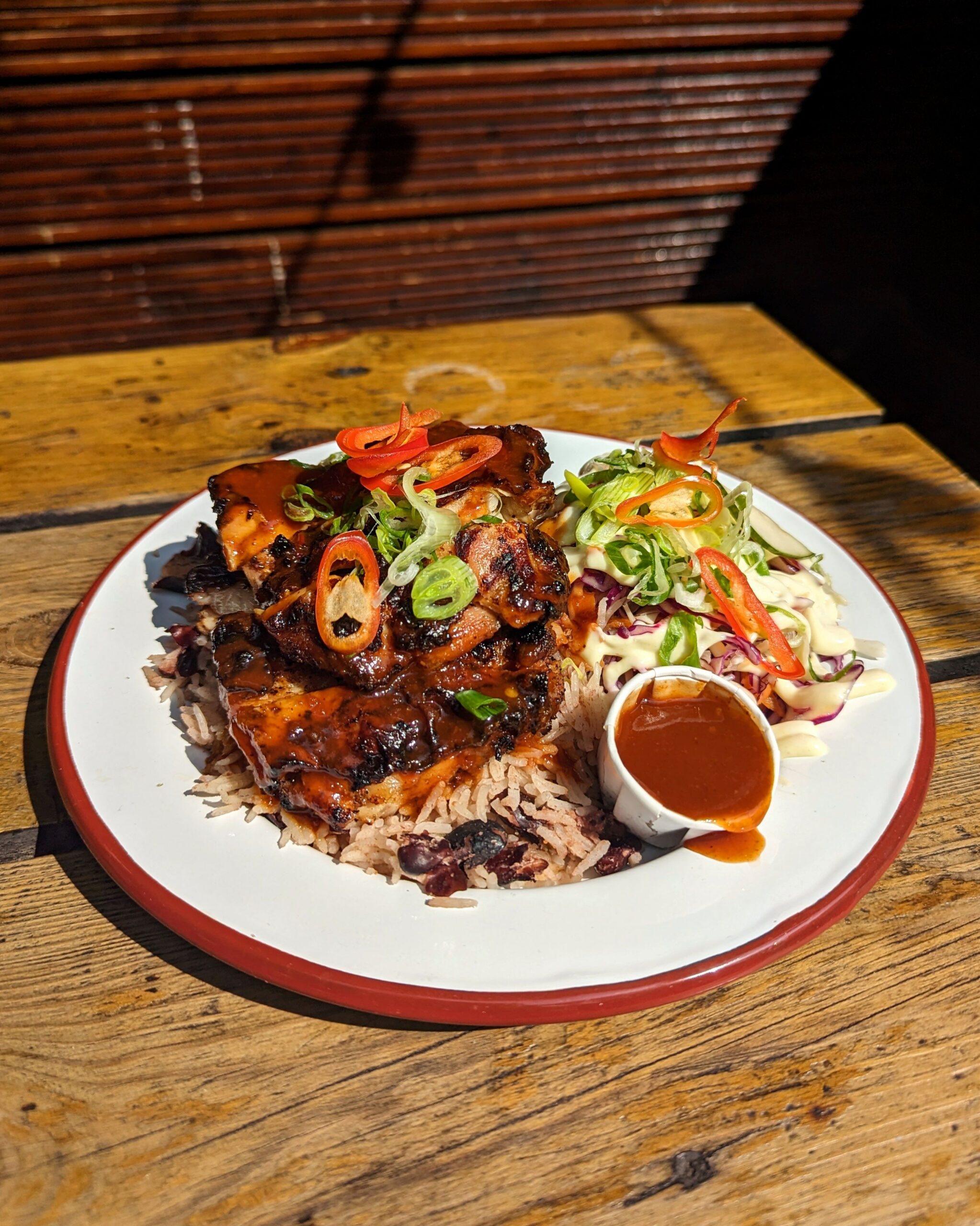 Jerk chicken with rice and peas, salad and chilli sauce